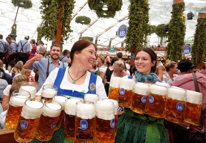Camareras llevan jarras de cerveza durante el día de apertura del Oktoberfest en Múnich (Alemania).