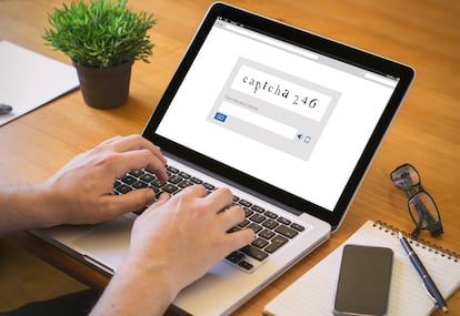 Close-up top view of a man writing captcha code on laptop