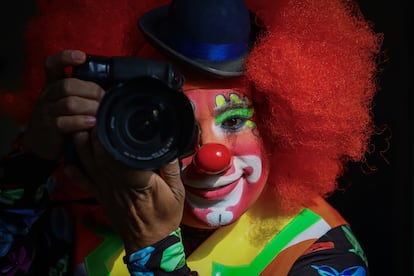 Juan Pérez, vestido de payaso, sostiene su cámara fotográfica, el 20 de diciembre de 2024, en Ciudad de México.
