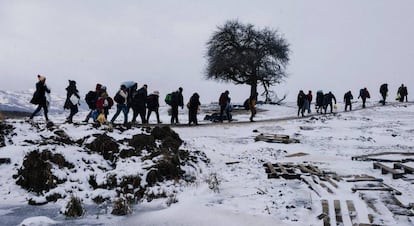 Un grupo de migrantes caminan por los campos cubiertos de nieve, después de cruzar la frontera con Macedonia en Serbia.
