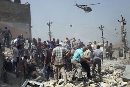 Equipos de rescate y vecinos buscan a supervivientes entre los escombros de uno de los edificios destruidos por los atentados de Bagdad.