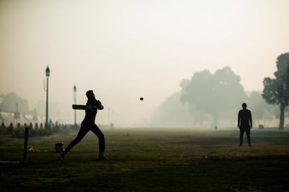 Varios jóvenes juegan al 'cricket' en un parque en Nueva Delhi (India).