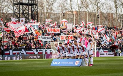 El once inicial del Rayo frente al Sevilla posa con su afición de fondo en el estadio de Vallecas, este domingo 19 de febrero.
