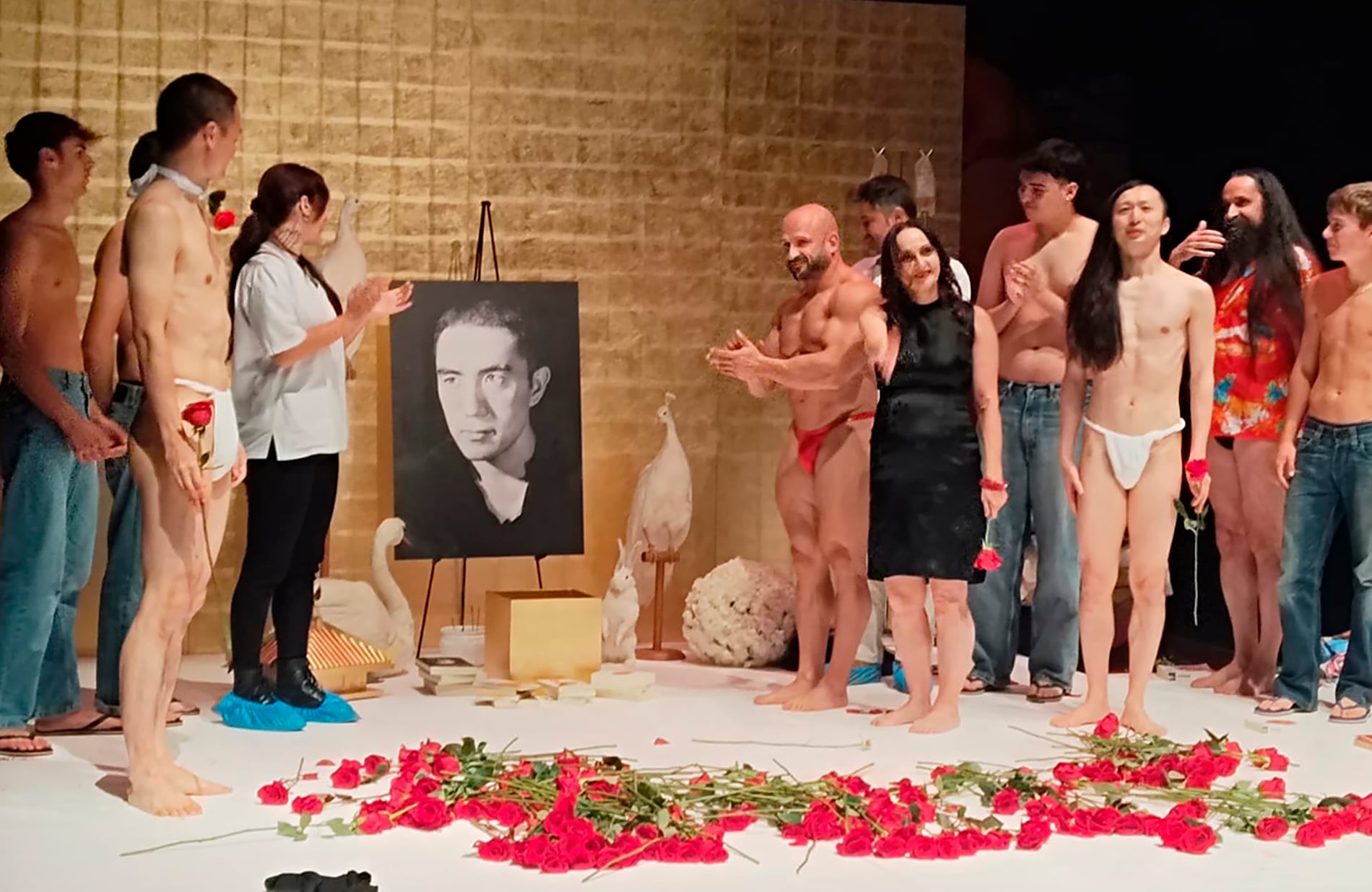 Angelica Liddell (vestido negro), rodeada de todo el equipo artístico, saluda al público al final de la función ante una fotografía del escritor Yukio Mishima.