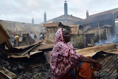 Una mujer se sienta en medio de los escombros de un mercado después de que un incendio destruyese el edificio durante la noche en el barrio de Abobo, en Abidjan (Costa de Marfil).