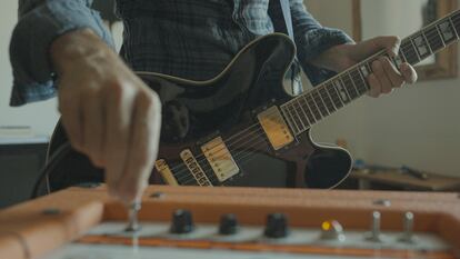 Un guitarrista rock toca la guitarra eléctrica en casa.