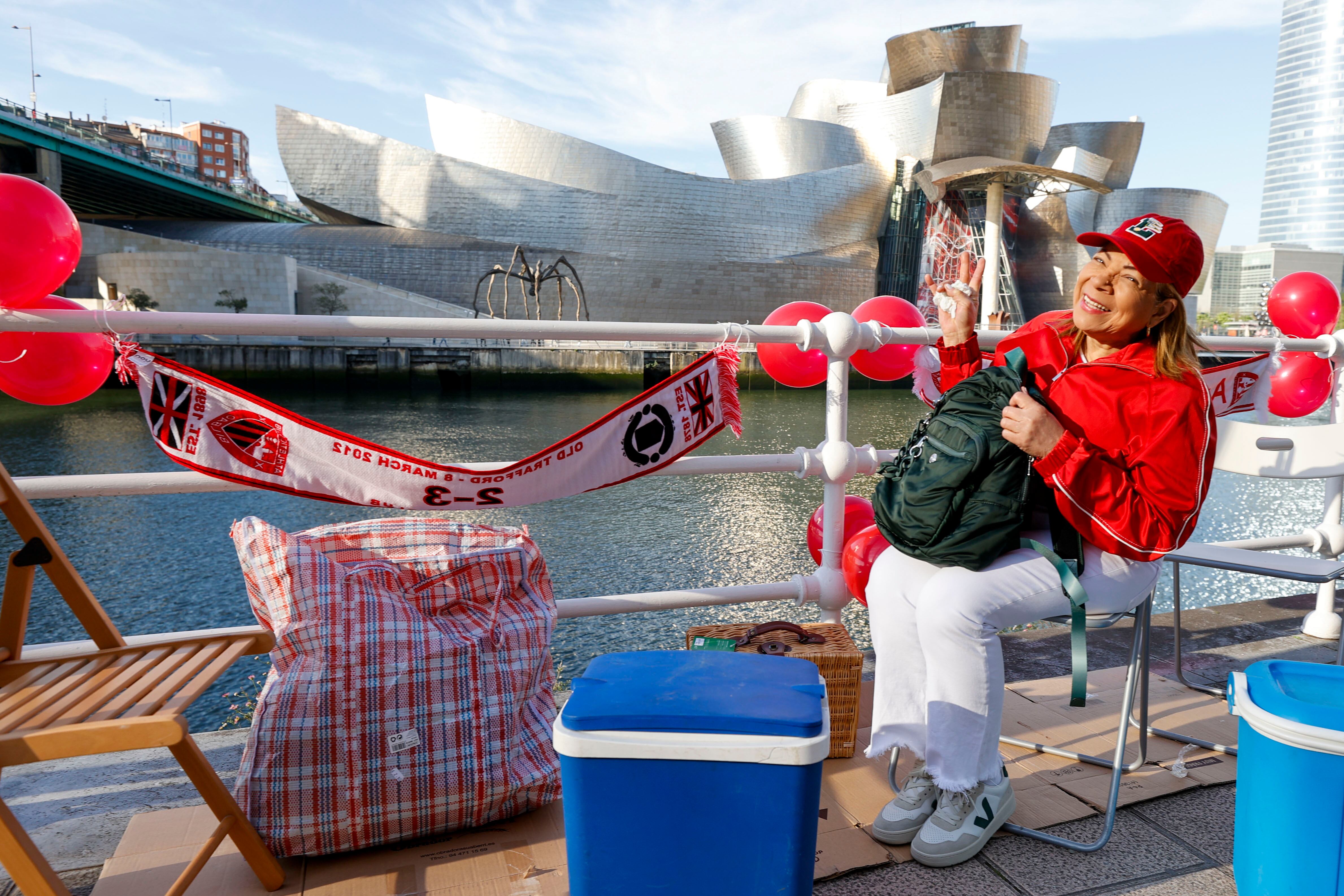 Sol de Medellín (Colombia) guarda el sitio para su cuadrilla que verán el paso de la gabarra frente al  Museo Guggenheim de Bilbao.