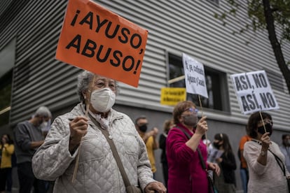 A protester holds a sign with the message: “Ayuso, abuse!” in reference to Madrid premier Isabel Díaz Ayuso.