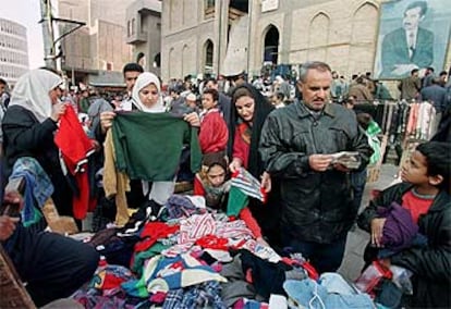 Ciudadanos iraquíes compran ropa de segunda mano en un mercado callejero de Bagdad.