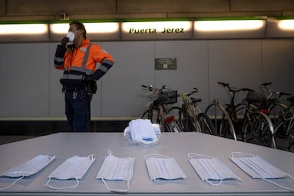 Un vigilante de seguridad, durante el reparto de mascarillas en la estación de metro de Puerta Jerez, en Sevilla.