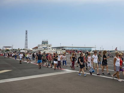 People cross a runway into Gibraltar.
