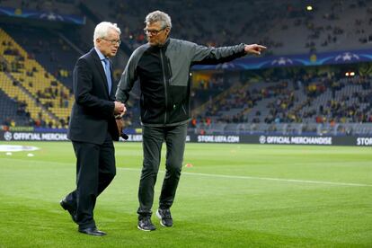 El presidente del Borussia de Dortmund Reinhard Rauball y el speaker del estadio del equipo alemán conversan procupados por el ataque de bomba que ha sufrido el autobús del equipo.