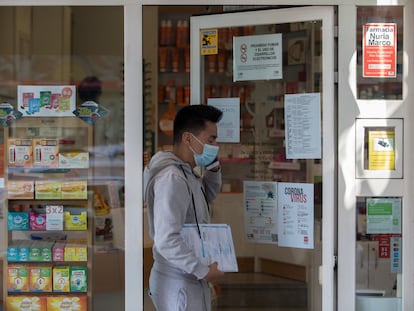 Un joven sale de una farmacia que anuncia en su fachada que tiene mascarillas en Madrid.