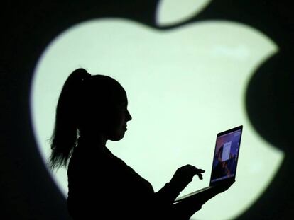 Silueta del logotipo de Apple con una mujer y un ordenador. 