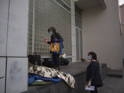 Dos voluntarias conversan con Tina, una mujer sin hogar que vive en las proximidades del MACBA, en Barcelona.