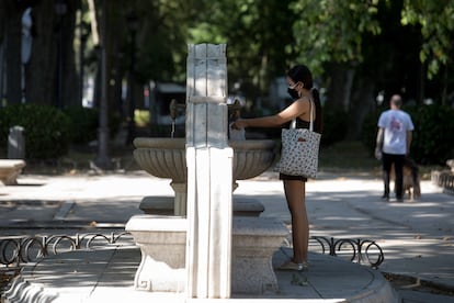 Una mujer junto a una de las fuentes del Paseo del Prado, este jueves.