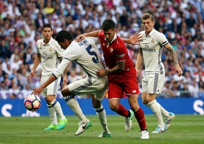 Stevan Jovetic (derecha) y Raphael Varane pelean por el balón.