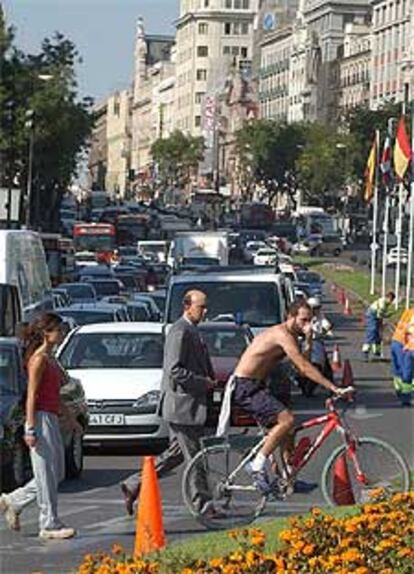 Un ciclista cruza por un paso de peatones de la madrileña calle de Alcalá, llena de coches esta mañana.
