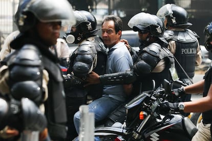 Membros da polícia Nacional da Venezuela prendem um manifestante contra o governo.