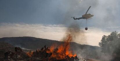 A helicopter flies over a burning fire in the Valencia province on Monday.