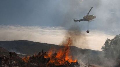 A helicopter flies over a burning fire in the Valencia province on Monday.