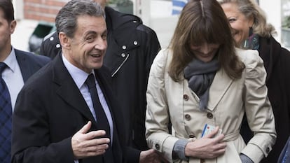 O ex-presidente francês Nicolás Sarkozy e sua esposa, Carla Bruni-Sarkozy, saem de um despacho de voto durante o primeiro turno das eleições primárias
