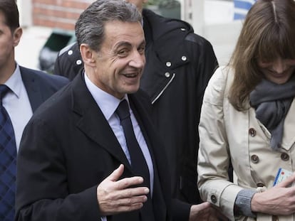 O ex-presidente francês Nicolás Sarkozy e sua esposa, Carla Bruni-Sarkozy, saem de um despacho de voto durante o primeiro turno das eleições primárias