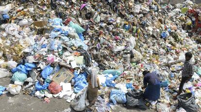 Ciudadanos indios rebuscan en un vertedero de plástico este martes, Día Mundial del Medio Ambiente centrado en este residuo.