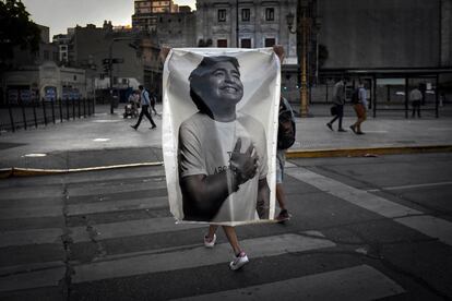 El velatorio de Diego Maradona ha terminado y la multitud abandona la Plaza de Mayo. Muchos se quedaron fuera de la Casa Rosada y no pudieron despedir al ídolo. En la foto, un hombre porta una foto del ídolo.