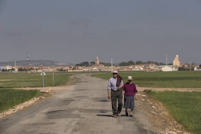 Dos vecinos del pueblo de Bello, Teruel, pasean los la carretera.