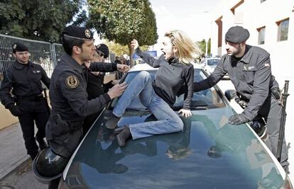 Isabel Monrós jumps on a Civil Guard vehicle as she tries to prevent her former husband from leaving with her children.