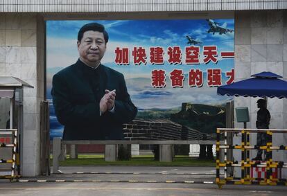 Un soldado hace guardia frente a un enorme retrato del presidente chino Xi Jinping en la entrada de una base militar en Guilin.