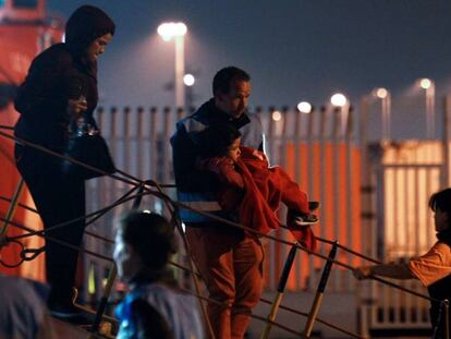 Un policía de Frontex baja al puerto de Algeciras a un bebé que viajaba en la embarcación Arcturus de Salvamento Marítimo, que rescató a 45 personas el pasado 23 de junio.