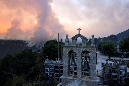 Una columna de humo de un incendio forestal, vista desde el cementerio de As Fermosas, en Ourense, este sábado.