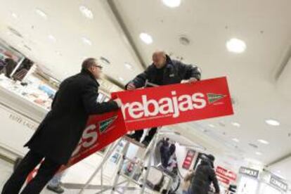 Empleados de un comercio de Madrid instalan los carteles de rebajas. EFE/Archivo