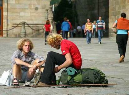 Dos peregrinos descansan en la Plaza del Obradoiro.
