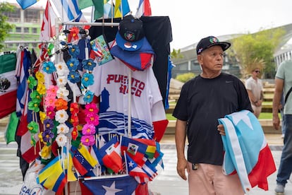 Camisetas, gorras, flores y banderas en venta afuera del Coliseo. 
