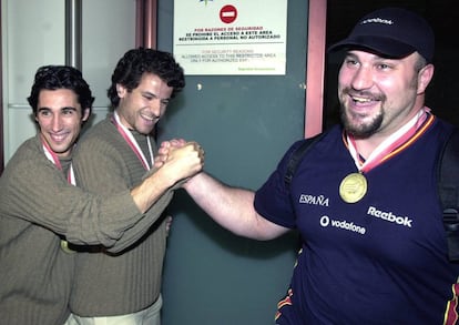 Los saltadores de longitud Raúl Fernández (i) y Yago Lamela (c), medallas de oro y plata respectivamente en los campeonatos europeos de atletismo en pisa cubierta, celebrados en Viena, bromean echando un pulso con Manuel Martínez (d), medalla de oro en lanzamiento de peso, a su llegada a Barajas, tras lograr el mayor éxito del equipo de atletismo en un campeonato de Europa con once medallas conseguidas, marzo de 2002.