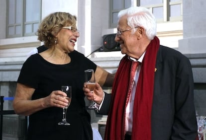 La alcaldesa de Madrid, Manuela Carmena, brinda con el presidente de la Fundación Mensajeros de la Paz, el padre Ángel, en la Galería de Cristal del Ayuntamiento de Madrid.