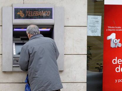 Un cliente bancario saca dinero de un cajero automático en Madrid, en una imagen de archivo.