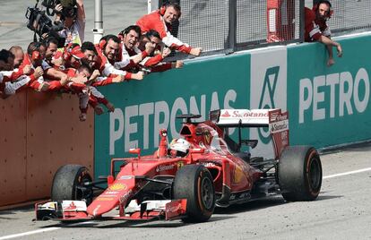 Vettel celebra la victoria con los miembros de Ferrari