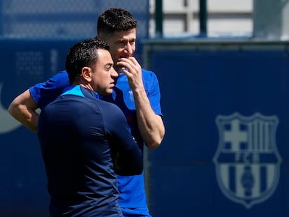 El delantero polaco del Barcelona, Robert Lewandowski, a la derecha, conversa con el entrenador, Xavi Hernández, durante el entrenamiento del equipo este sábado.