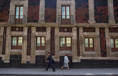 Gente camina frente a un edificio ligeramente inclinado, en el Centro Histórico de la Ciudad de México.