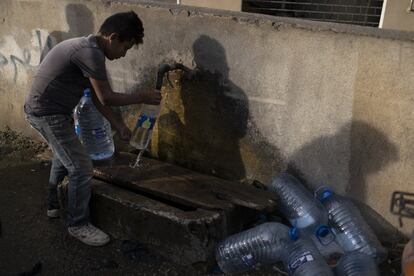 Un niño rellena una garrafa de agua y varias botellas en una fuente pública en el municipio de Byblos, al norte de Beirut. El Fondo de Naciones Unidas para la Infancia (Unicef) ha alertado que en Líbano la mayoría de niños y familias vulnerables se enfrentan a una grave escasez de agua, cuatro millones están en riesgo inminente de perder el acceso al suministro.