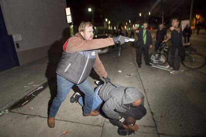 Un oficial de policía vestido de paisano detiene a uno de los manifestantes en una protesta contra la policía en la ciudad de Oakland, California.