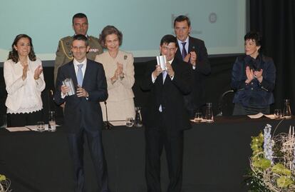 La Reina aplaude a dos de los premiados.