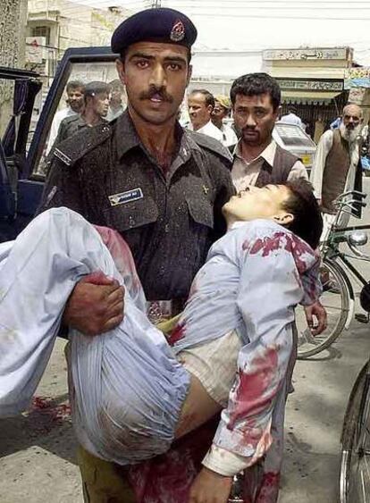 Un policía paquistaní lleva en brazos a un hombre herido en un atentado en Quetta.