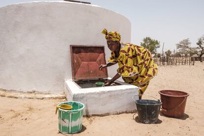 Mboya Ka es la primera beneficiaria en Senegal. A apenas 10 metros de su cabaña, en un placa se lee: “Cisterna número 1”. Luce blanca y limpia. “Ha mejorado mi vida y la de mi familia. Antes tenía que andar siete kilómetros para ir a recoger el agua. Iba por la mañana y volvía de noche. O usaba un carro por el que tenía que pagar 1.000 francos (1,5 euros). Ahora tengo más tiempo para cocinar, para descansar, para cultivar el nuevo huerto o para hablar con las otras mujeres a la sombra”, señala Ka, precisamente a la sombra de la plancha de aluminio inoxidable de 60 metros cuadrados que recoge el agua durante la estación de lluvia y mediante un canalón la lleva hacia la cisterna. “Esta sombra nos ha venido muy bien, aquí hace mucho calor. Ahora hacemos reuniones y nos sentamos a charlar y resolver nuestros problemas”, detalla la mujer sobre una alfombra como una de las ventajas imprevistas de la instalación. En la imagen, Mboya Ka, abre la trampilla de la cisterna en Douly, en la región de Louga, en Senegal.