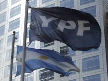 Detalle de las banderas de Argentina y de la petrolera YPF, frente al edificio donde funcionan las oficinas centrales de la empresa en Buenos Aires. EFE/Archivo