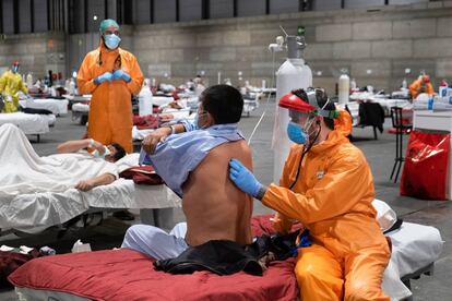 Profissionais sanitários atendem pacientes no pavilhão 5 da Ifema, habilitado como hospital de campanha, em Madri.